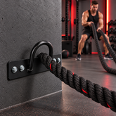 Black battle rope wall anchor installed in a home gym with rope in use