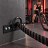 Black battle rope wall anchor installed in a home gym with rope in use