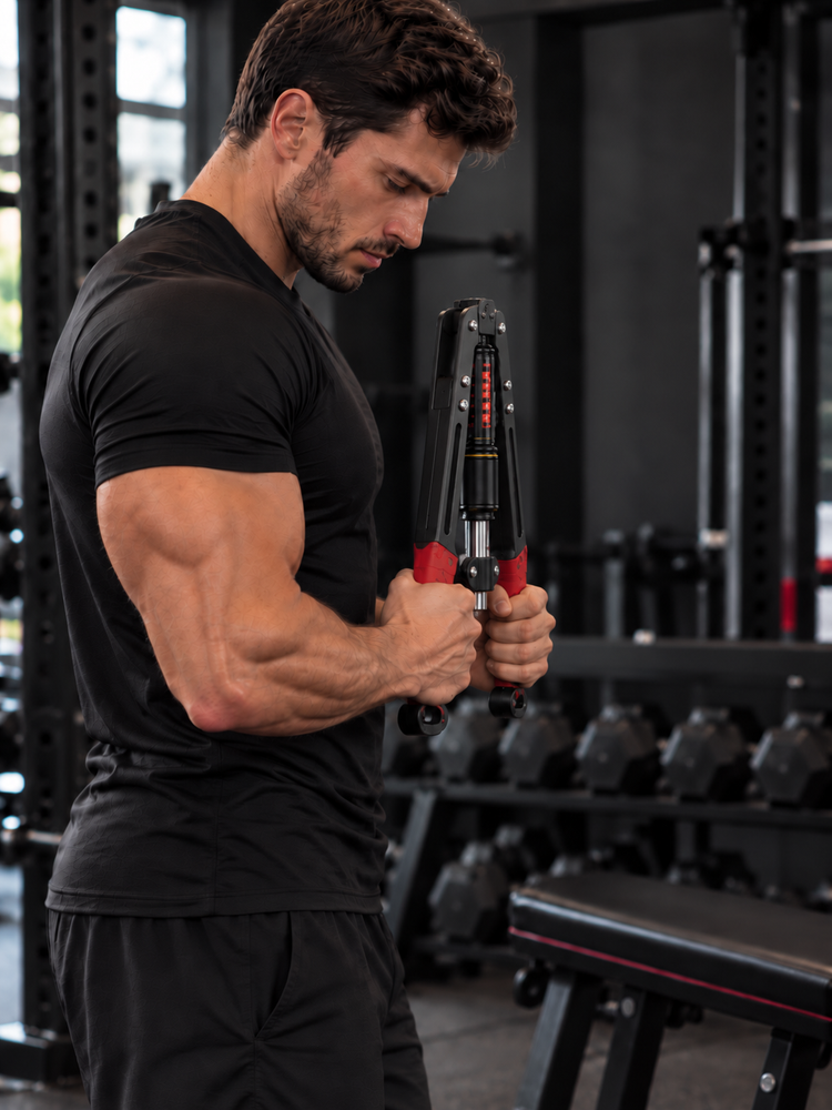 Hydraulic arm trainer demonstrated from the side in a gym