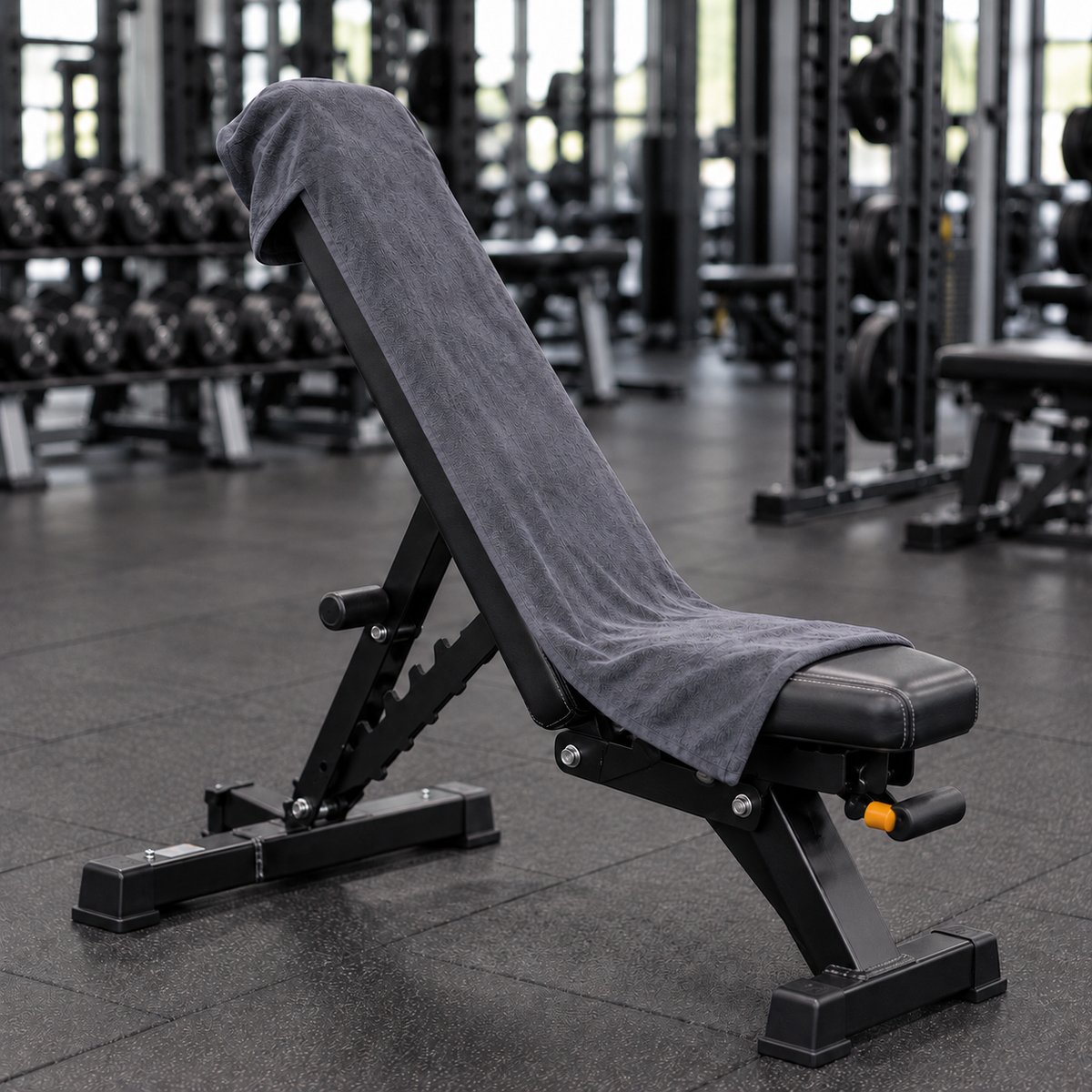 Charcoal grey hooded gym towel covering the front of an incline workout bench